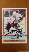 Front side of Mike Fisher Ottawa Senators hockey card with autograph in black marker on player's image.