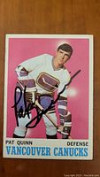Front view of Pat Quinn Vancouver Canucks hockey card with signature visible
