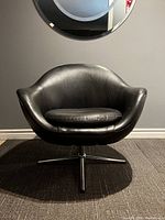 Front view of chair showing curved pod shape, cushion and base