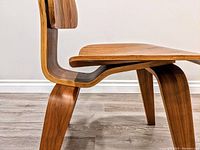 Close-up side view of bentwood leg and seat edge showing layered plywood and veneer finish