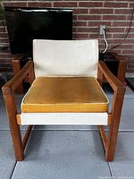 Front view of vintage IKEA Safari chair with beige fabric sling and mustard yellow cushion.