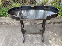 Full view of the black wooden table showing oval top, edges and stand