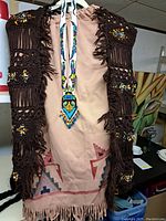 Full garment with dark brown crocheted overlay and multicolored beaded necklace displayed on a mannequin.