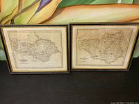 Both framed maps displayed side by side on a dark surface