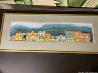 Full view of framed print showing entire artwork and frame on dark table surface.