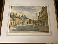 Framed pastel picture showing a street view with a cloudy sky and houses with chimneys; two figures walking in foreground