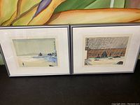 Pair of framed Japanese prints displayed side by side showing water and pavilion scenes