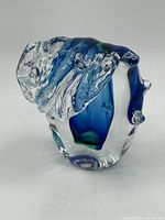 Side view showing blue glass cresting over clear base with organic shapes and ridges.