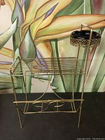 Front view of vintage metal magazine stand with integrated ashtray showing overall structure and design.