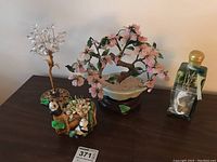 Metal tree with crystal leaves, wax bonsai tree, ceramic panda figurine and glass oil candle on table