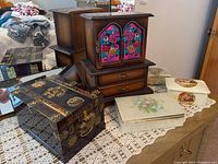 Photo showing all 5 boxes arranged on lace cloth including the dark wood music jewelry box, black onyx box, ceramic and black trinket boxes.