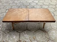 Photo of the wooden low folding table with two panels and folding legs, showing surface and structure.