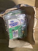 Five individually bagged Starting Lineup NFL Steelers figures inside a paper bag