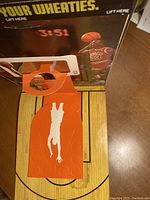 Top-down view inside the box showing the basketball hoop and half-court graphic with a water stain visible on half-court.