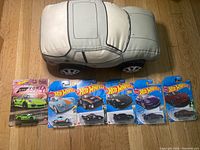 Photo showing vintage Porsche 924 plush toy and six Hot Wheels Porsche cars in packaging including a Forza Horizon 4 edition green Porsche.