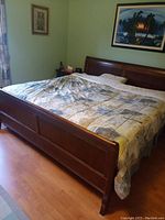 Angled view of assembled sleigh bed frame with bedding