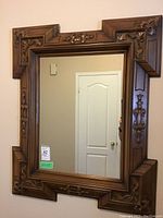 Full frontal view of the solid oak carved wood framed mirror hanging on a wall, showing intricate woodwork around the edges.