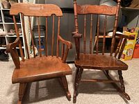 Front view of two wooden child rocking chairs side by side on carpet, showing different backrest styles and armrests.