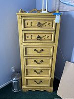 Front view of vintage lingerie chest showing six drawers and decorative metal handles in honey oak finish