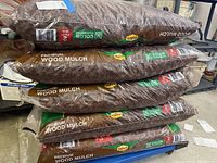 Five stacked bags of Vigoro Premium Wood Mulch, showing labels and measurements.