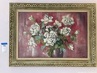 Framed wall art painting of white roses, shown against a white wall with auction tag visible.