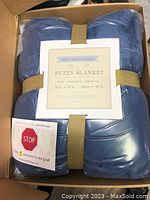 Blue fuzzy blanket folded and packaged with label showing size 108 x 90 inches and Rose Home Fashion brand