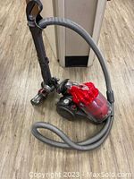 Full view of Dyson DC32 canister vacuum showing hose, wand, and dust bin