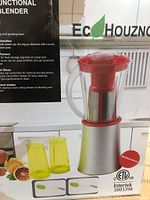 Box packaging showing EcoHouzng multi-functional blender with two yellow blending jars and product information.