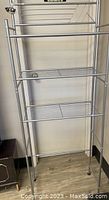 Front view of the silver 3-tier bathroom storage rack showing the open wire shelves and frame.