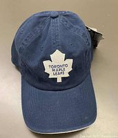 Front view of navy blue Toronto Maple Leafs cap showing embroidered logo and curved brim.