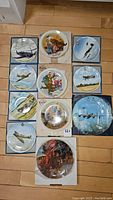All 12 Battle of Britain fine bone china collector plates arranged on floor with some original boxes.