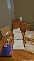 Photo of all collector plates in original packaging, including a purple Wedgewood box and several brown cardboard boxes.