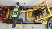 Top view of yellow hydraulic motorcycle lift showing the pump, handle, and lift platform with model number 34730 sticker.