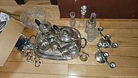 Full lot showing silver plated tea service items on tray with crystal decanters and glassware