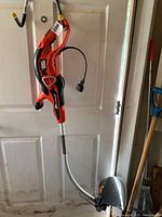 Full view of the Black and Decker GrassHog XP corded electric weed wacker with visible curved shaft and power cord