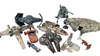 View showing six Star Wars spacecraft models including Millennium Falcon, X-wing, TIE Fighter, Naboo Starfighter, and smaller starfighters with some loose parts.