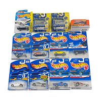 Top-down image showing all 13 Hot Wheels cars in original packaging arranged in rows, displaying different models and packaging styles including Super Wheels and 1998 First Editions.