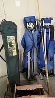 Photo showing three folding camping chairs, two blue and one in green carrying bag labeled "Folding Chair Chase Plaid"