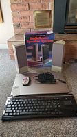 Overview of all items: boxed NEC AudioTower speaker system, two satellite speakers, Logitech keyboard, remote, Dell laptop closed
