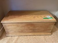 Front view of rectangular wooden storage box with flat top and natural wood finish.