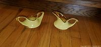 Pair of vintage yellow ceramic cream and sugar pieces with gold trim, shown on a wooden surface.