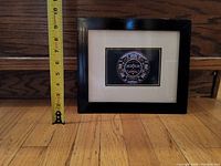Framed print with measuring tape showing height near 10 inches