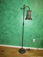 Full view of the vintage metal floor lamp approximately 60 inches tall with curved arm holding the ornate shade.