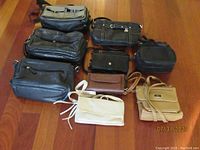 Nine pocketbooks arranged on hardwood floor in varied colors and designs