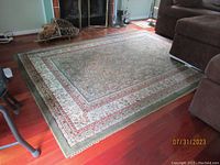 Rug laid out on a wood floor with furniture visible around it, showing overall size and pattern layout.
