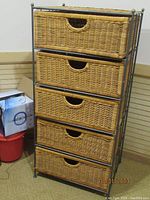 Front view of 5-drawer wicker basket storage tower in black metal frame.