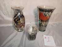 Full view of three jars containing various costume jewelry pieces including necklaces, bracelets, rings, earrings, beads, and metal parts.