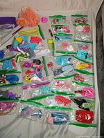 Overview of the 30 sets of vintage Barbie and Ken clothes and accessories in clear baggies, including a variety of tops, skirts, and dresses.
