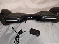 Full hoverboard black color with textured footpads, LED lights on sides glowing white