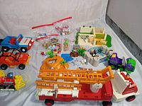Wide angle photo showing all vintage toys in the lot including Playmobil set and multiple toy vehicles